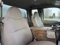 Interior of a 2008 Ford F-450 featuring two fabric seats with a wooden console in between the front seats