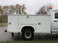 A 2013 RAM 3500 utility truck with a white service bed and orange emergency lights on top