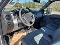 The interior of a 2016 Ford F-250 SD featuring a steering wheel dashboard controls and light gray seating