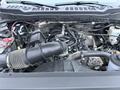 The engine compartment of a 2023 Ford F-250 featuring various components including hoses a large air intake and visible engine parts