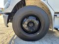 A close-up of the wheel of a 2006 Freightliner M2 106 showcasing a black tire with visible bolts and a shiny rim