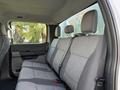 Interior view of a 2024 Ford F-550 showing the rear bench seat with gray upholstery and seat belts
