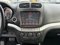 Dashboard of a 2013 Dodge Journey featuring a touchscreen display with radio information and control buttons for climate and audio settings