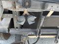 Two horn components mounted on the chassis of a 2012 Ford Econoline visible in close up detail