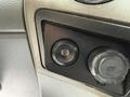 A control panel featuring a circular button labeled with a symbol and a 12V power outlet in a 2019 Ford F-750 interior