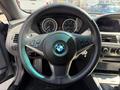 A 2004 BMW 6-Series steering wheel featuring the BMW logo and integrated controls for audio and cruise settings
