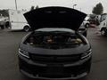 A 2017 Dodge Charger with its hood open revealing the engine compartment which has various components including a large intake and black tubing