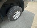 A close-up of a tire on a 2015 RAM 1500 showing a rugged tread design and the vehicle's alloy wheel