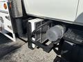 A 2006 International 4300 with a large black radiator and a cylindrical gray component attached beside the front wheel