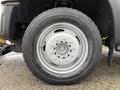 Close-up of a silver steel wheel with a radial tire from a 2013 Ford F-450 SD showing detailed tread pattern and wheel design