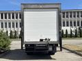 A rear view of a 2018 Hino 195 box truck with a white cargo area and black chassis parked on a paved surface