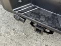 A black tow hitch attached to the rear of a 2011 Ford F-350 SD with a rounded connector and a square opening for towing accessories
