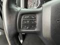 Close-up of a steering wheel controls in a 2018 RAM 1500 featuring buttons for voice activation phone settings and navigation controls
