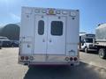 Rear view of a white 2011 Chevrolet Express with double doors and rear lighting fixtures