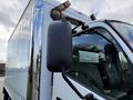 A 2014 Hino 195 truck featuring a black side mirror and amber clearance lights on the roof