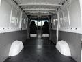 Interior of a 2016 Mercedes-Benz Sprinter van featuring a spacious cargo area with two front seats and a partition for security