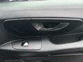 A black interior door panel of a 2021 Mercedes-Benz Metris featuring control buttons for windows and door locks