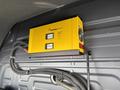 A yellow SamlexPower automatic battery charger mounted on the wall inside a 2019 Mercedes-Benz Sprinter van