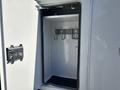 An open storage compartment of a 2013 International 7500 with hooks and mounting brackets inside