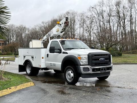 A 2012 Ford F-450 Super Duty truck with a utility body and a mounted aerial lift on the roof