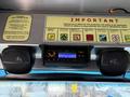 A 2012 Ford Econoline dashboard featuring a stereo system and two speakers