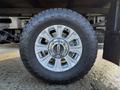 A close-up of a 2020 Ford F-350 wheel showcasing a silver alloy rim and a rugged tire with distinctive tread patterns
