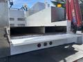 2006 International 4300 with an open flatbed and visible storage compartments on the side