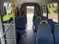 Interior view of a 2013 Ford Econoline with blue seats and yellow handrails arranged in rows along the aisle