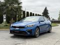 A blue 2021 Kia Forte parked on a paved surface showcasing its sleek design and modern features