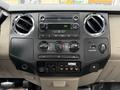The dashboard of a 2008 Ford F-350 featuring audio controls climate controls and various buttons including a beacon switch