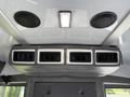 The image shows the ceiling interior of a 2020 Chevrolet Express with air vents and speakers mounted above a gray upholstered area