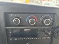 Dashboard controls of a 2018 Chevrolet Express featuring climate control knobs and a digital display for audio settings