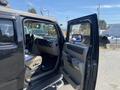 A black 2003 Hummer H2 with its driver side door open showing the interior features like the dashboard and seating