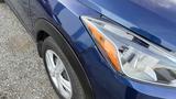 A 2019 Nissan Kicks with a blue exterior is partially visible showcasing its front headlight and tire with fine details on the bodywork and wheel design