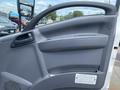 The interior door panel of a 2019 Isuzu NRR featuring a handle and control buttons in a grey finish