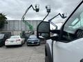 A white 2023 Ford F-450 Super Duty pickup truck with a prominent side mirror is in the foreground