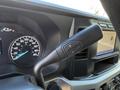 Close-up of the gear shift lever in a 2024 Ford F-550 with controls for manual shifting and a digital speedometer display in the background