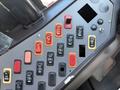 A control panel featuring multiple switches and buttons in various colors including red yellow and black for a 2011 Freightliner B2