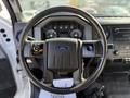 A steering wheel with the Ford logo and control buttons, part of the interior of a 2018 Ford F-750, showcasing the dashboard and control panel