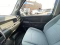 Interior view of a 2016 RAM 5500 featuring a driver seat with light upholstery and a minimalistic dashboard with controls and storage compartments