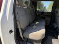 The interior of a 2019 Ford F-350 SD featuring gray cloth seats in the back row with seat belts and a spacious layout