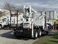A white 2008 Kenworth T370 truck with a large aerial lift attachment on the back designed for utility work