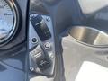 A close-up of the control panel of a 2013 Larson 238 featuring two black buttons labeled "STEERED" and "ACC" along with a round cup holder and a gauge showing volts
