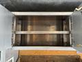 Empty metallic storage compartment of a 2011 Workhorse W62 with two shelves and a smooth interior surface