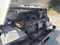The image shows the engine compartment of a 2012 Ford Econoline with various engine components and a visible battery on the left side
