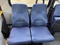 Two blue upholstered seats from a 2017 Chevrolet Express van are positioned next to each other with a textured surface and a streamlined design