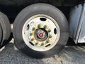 A close-up view of a wheel from a 2011 Autocar Xpeditor showcasing the metal rim and a tire with visible wear and a wheel hub featuring bolts and a central red cap