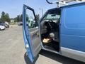 A blue 2005 Ford Econoline van with an open door showing the driver's seat and dashboard inside the vehicle