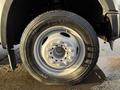 A close-up of a wheel and tire from a 2010 Ford F-550 showing a silver rim and all-season tread pattern