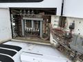 Exposed electrical control panel of a 2012 Global M4 with numerous fuses and wiring connections visible inside an open compartment